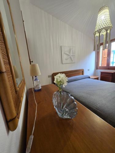 a bedroom with a bed and a table with flowers on it at Golden Dune View in Torre Dei Corsari