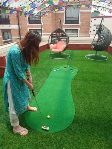 a young girl playing golf on a miniature golf course at Apartment Hotel 11 Thamel in Kathmandu