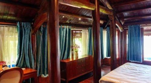 a bedroom with a bed with blue drapes at Jun's Home in Buon Ma Thuot