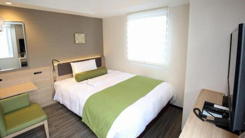 a bedroom with a large bed and a television at KEIKYU EX INN Hamamatsucho Daimon-Station (Tokyo) in Tokyo