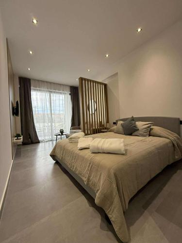 - une grande chambre avec un grand lit et une grande fenêtre dans l'établissement JD Studios Kalithea, à Kallithéa Halkidikis
