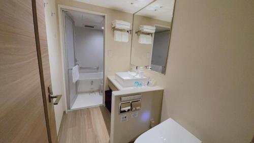 a bathroom with a sink and a toilet and a mirror at KEIKYU EX INN Hamamatsucho Daimon-Station (Tokyo) in Tokyo