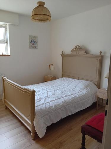 - une chambre avec un grand lit et un couvre-lit blanc dans l'établissement Maison au coeur du village, à Dorlisheim