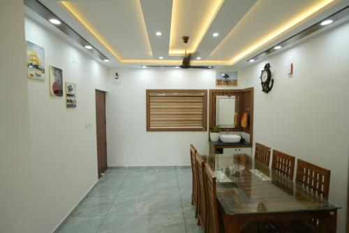 a dining room with a glass table and chairs at Wayanadan Huts Homestay in Sultan Bathery