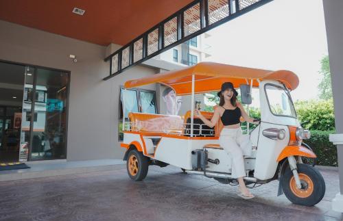 a woman is sitting on a food cart at Cmor by Recall Hotels SHA Extra Plus in Chiang Mai