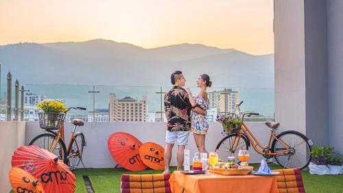 a man and woman standing on top of a balcony at Cmor by Recall Hotels SHA Extra Plus in Chiang Mai