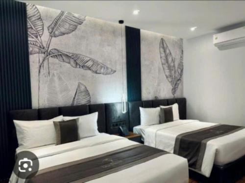 a bedroom with two beds and a painting on the wall at SUMI ĐAMI homestay in Da R'soung