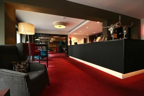 a lobby with a red carpet and a bar at Hotel Haverkamp in Bremerhaven