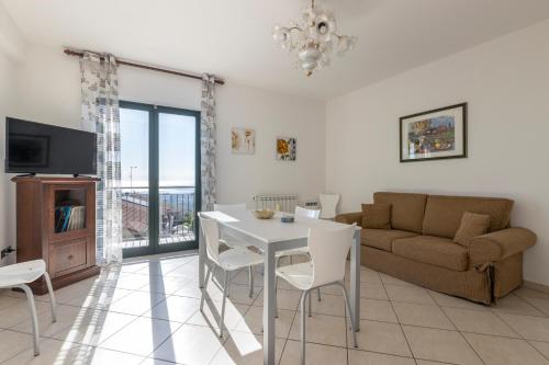 a living room with a table and a couch at Little Rose garden in Aci Catena