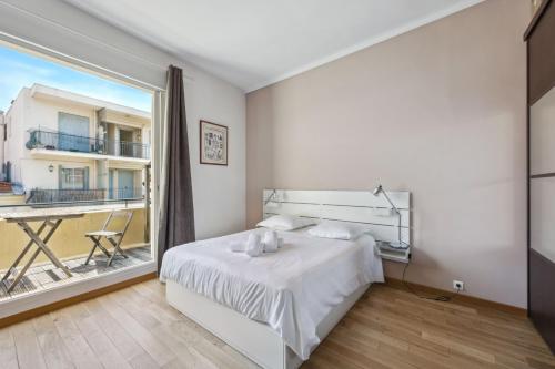 une chambre avec un lit et une grande fenêtre dans l'établissement Le Blacas, à Nice