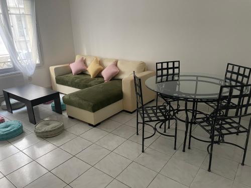 un salon avec un canapé et une table en verre dans l'établissement Au soleil, à Toulon