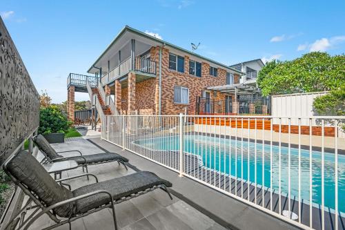 a balcony with chairs and a swimming pool at Seascape Retreat at Bonny Hills in Bonny Hills
