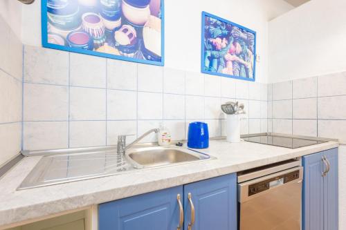 a kitchen with a sink and blue cabinets at Casa Maris in Port d'Alcudia