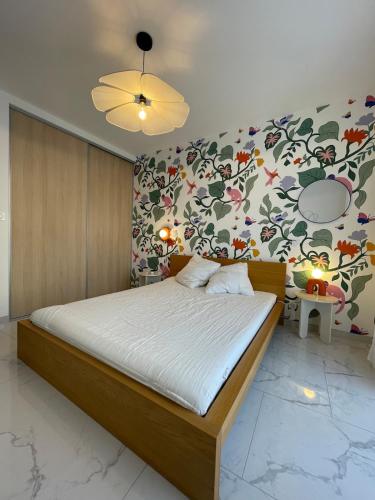 - une chambre avec un grand lit et un mur fleuri dans l'établissement Appartement 3 chambres, à Propriano