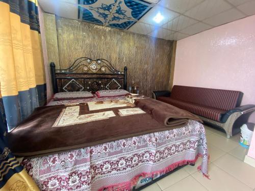 a bedroom with a large bed and a bench at 2 Bedrooms innara Rooms Bhurban A1 in Bhurban