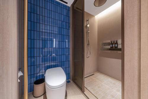 a bathroom with a toilet and a blue tile wall at Orange Crystal Chengdu Financial City South Railway Station Hotel in Chengdu