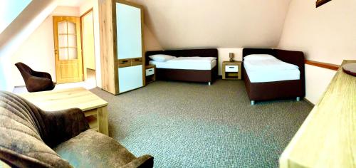 a small room with two beds and a couch at Hotel Bílý Beránek Kralovice in Kralowitz