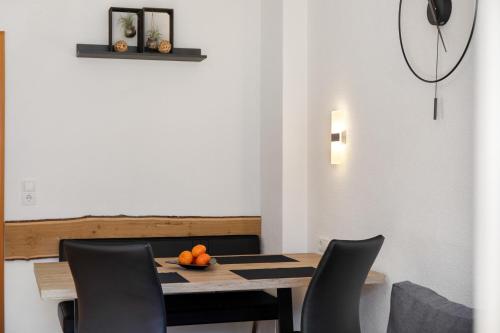 a dining room with a table with chairs and oranges on it at Apart Annabell in Habichen