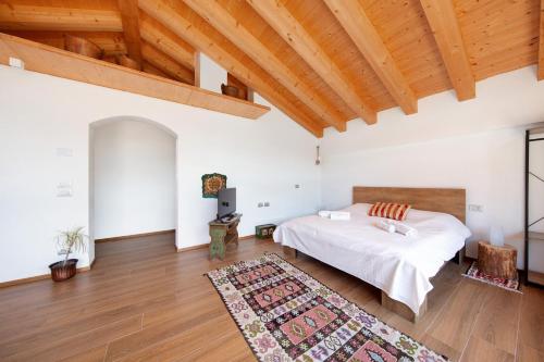 a bedroom with a bed and a wooden ceiling at Le Nene - Dolomiti guesthouse in Pieve di Cadore