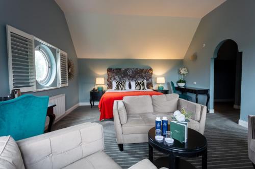 a bedroom with a bed and a couch and a table at Killaloe Hotel & Spa in Killaloe