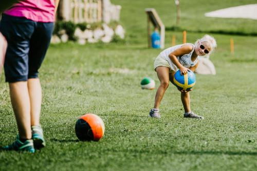 a young girl playing with a ball on a field at Landhaus Riepler in Wagrain