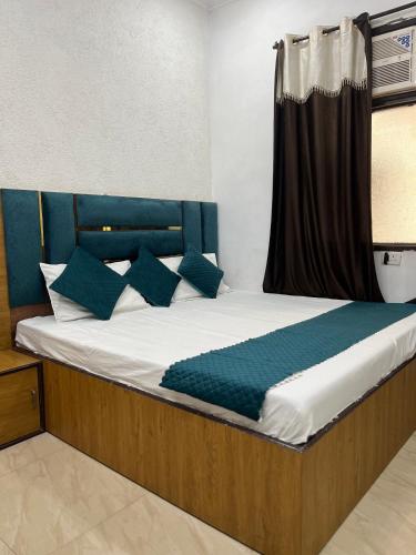 a bedroom with a bed with blue pillows at Sharma's BNB in Amritsar