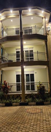 a large white building with balconies and a pole at Efrona Homes in Kampala