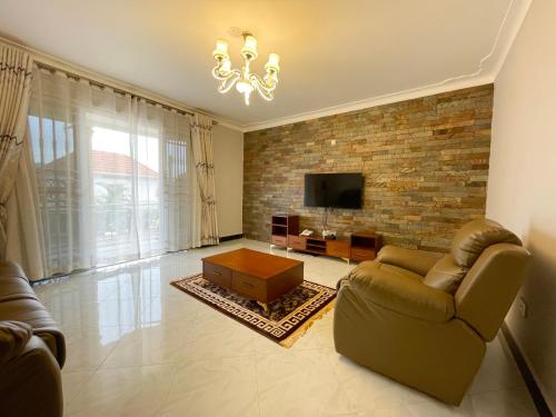 a living room with a couch and a tv at Efrona Homes in Kampala