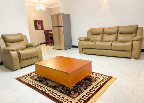 a living room with two couches and a coffee table at Efrona Homes in Kampala