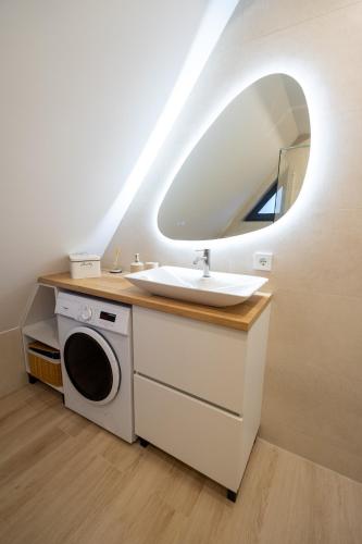a bathroom with a sink and a washing machine at Holiday home Pine nest in Široki Brijeg