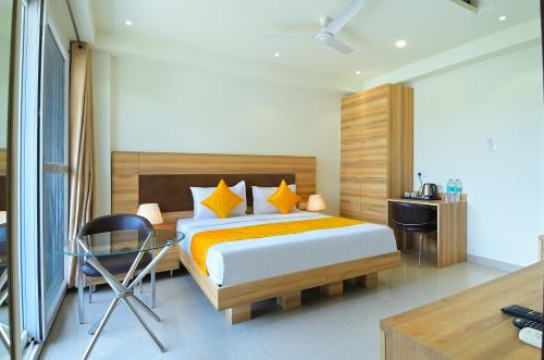a bedroom with a bed with a desk and a chair at My hotel Sector 23 Near Yashobhoomi Dwarka in New Delhi
