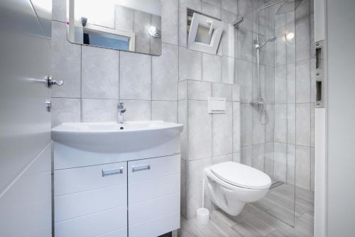 un bagno bianco con un water e un lavandino di Villa Baras garden - house with pool a Mirce