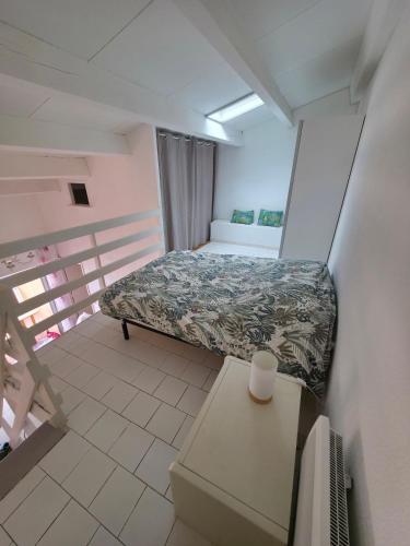 une petite pièce avec un lit et une table dans l'établissement BaroZig, à Frontignan