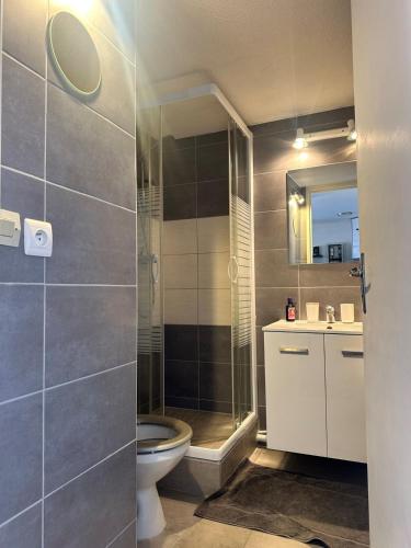 une salle de bain avec toilettes et douche en verre dans l'établissement BaroZig, à Frontignan