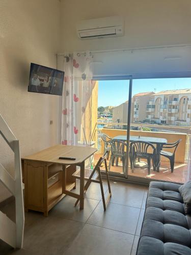 d'un salon avec une table et un balcon. dans l'établissement BaroZig, à Frontignan