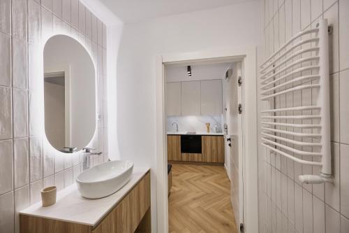 斯维诺乌伊希切Apartamenty Nautilus 103的一间白色浴室，配有洗手池和镜子。
