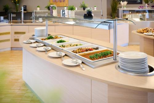 a buffet line with plates and food on it at JUFA Hotel Wien City in Vienna