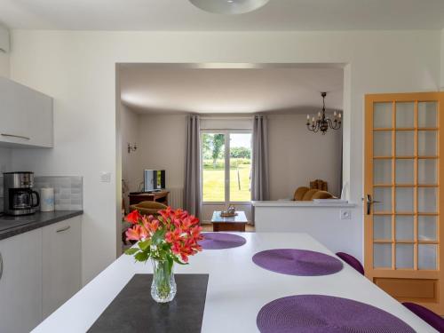 une cuisine avec une table avec un vase de fleurs dessus dans l'établissement Maison familiale terrasse et parc, à Plouisy
