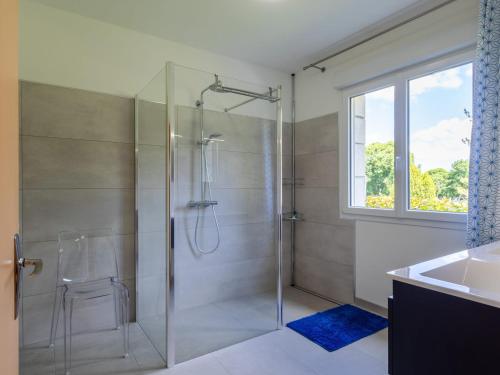 un bagno con doccia in vetro e lavandino di Maison familiale terrasse et parc a Plouisy