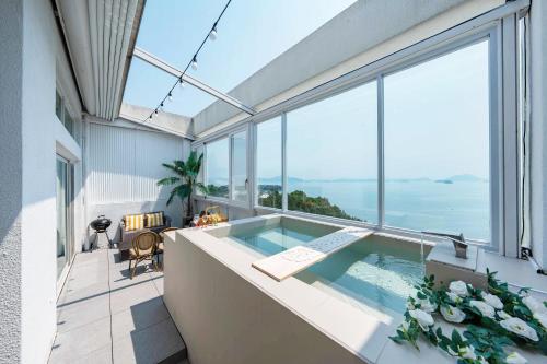 a house with a swimming pool and large windows at Yeosu Ekklesia Pool Villa N Jacuzzi in Yeosu