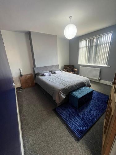 a bedroom with a bed and a blue rug at Giga Residential 4 Bedrooms, 8 guests , Near City Centre, Arcade Machine, Sky TV, Netflix, Free Wifi, Free Parking in Newcastle upon Tyne