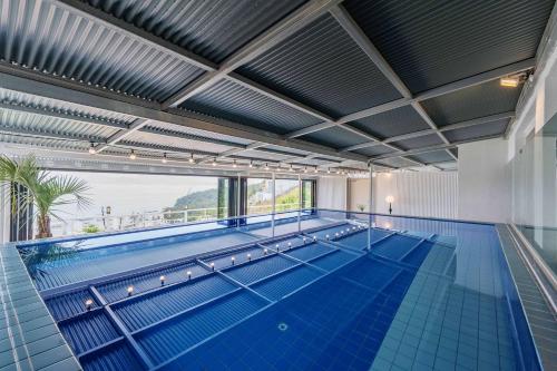 a large swimming pool with a large window in a building at Yeosu Ekklesia Pool Villa N Jacuzzi in Yeosu