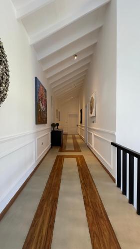 a hallway in a building with white walls and wooden floors at Benito Bungalow, Haputale by The Serendipity Collection in Haputale