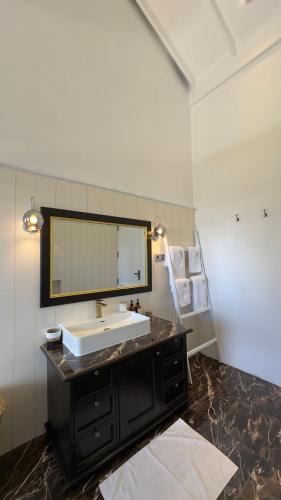 a bathroom with a sink and a mirror at Benito Bungalow, Haputale by The Serendipity Collection in Haputale