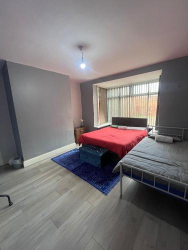 a bedroom with a red bed and a window at Giga Residential 4 Bedrooms, 8 guests , Near City Centre, Arcade Machine, Sky TV, Netflix, Free Wifi, Free Parking in Newcastle upon Tyne