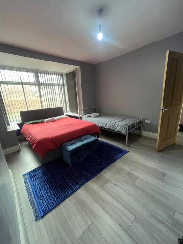 a bedroom with a red bed and a blue rug at Giga Residential 4 Bedrooms, 8 guests , Near City Centre, Arcade Machine, Sky TV, Netflix, Free Wifi, Free Parking in Newcastle upon Tyne