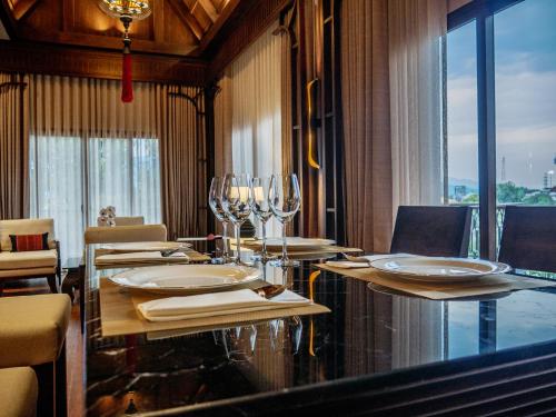 a dining room with a table with wine glasses at S48 River Ping in Chiang Mai