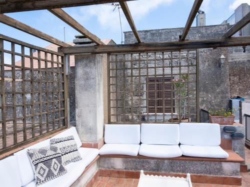 a patio with white couches on a balcony at La Dimora del Re in Erice