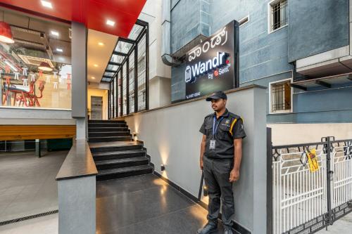 a man in uniform standing in front of a building at Wandr Hotel- Near MG Road in Bengaluru