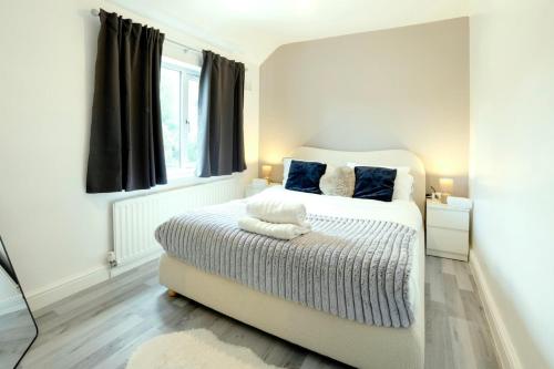 une chambre blanche avec un lit et une fenêtre dans l'établissement Stunning Lux 3 Bedroom home Priv Parking in Birmingham, à Kings Norton